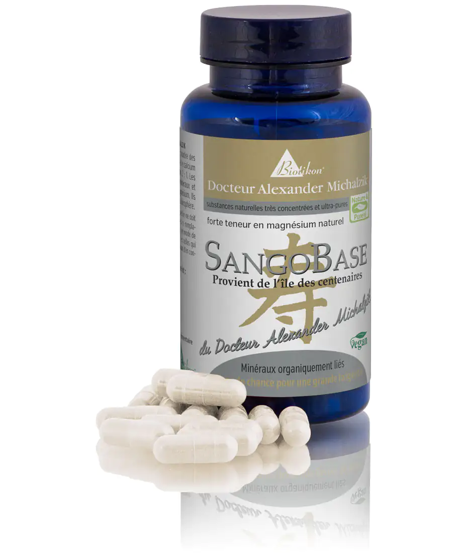 SangoBase – Capsules de Magnésium 60 pièces Capsules SangoBase dans une bouteille bleue, 60 capsules blanches sur une table, visibles sous la lumière.