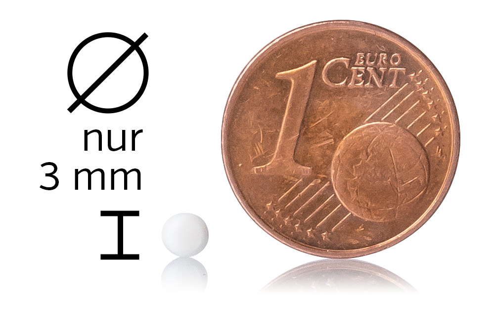 Pilule Micro 3 mm – Comprimé Blanc Pilule micro blanche de 3 mm de diamètre à côté d'une pièce de 1 centime sur un fond blanc.