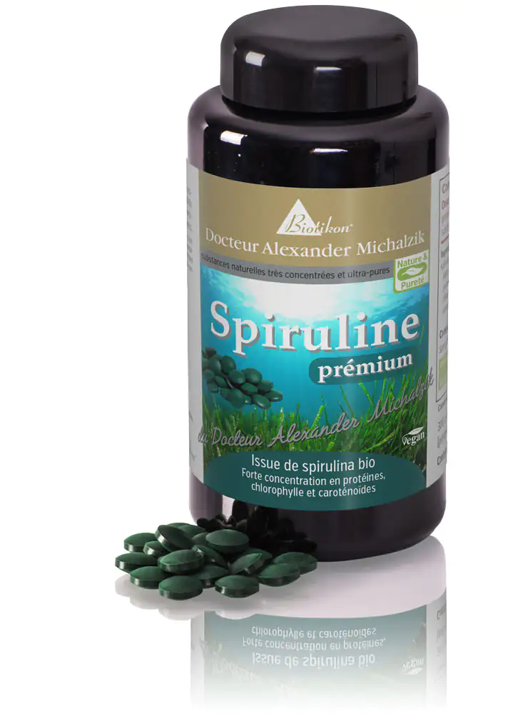 Spiruline Premium – 180 Comprimés Bouteille de comprimés de spiruline verte, 180 pièces, quelques comprimés visibles au premier plan.